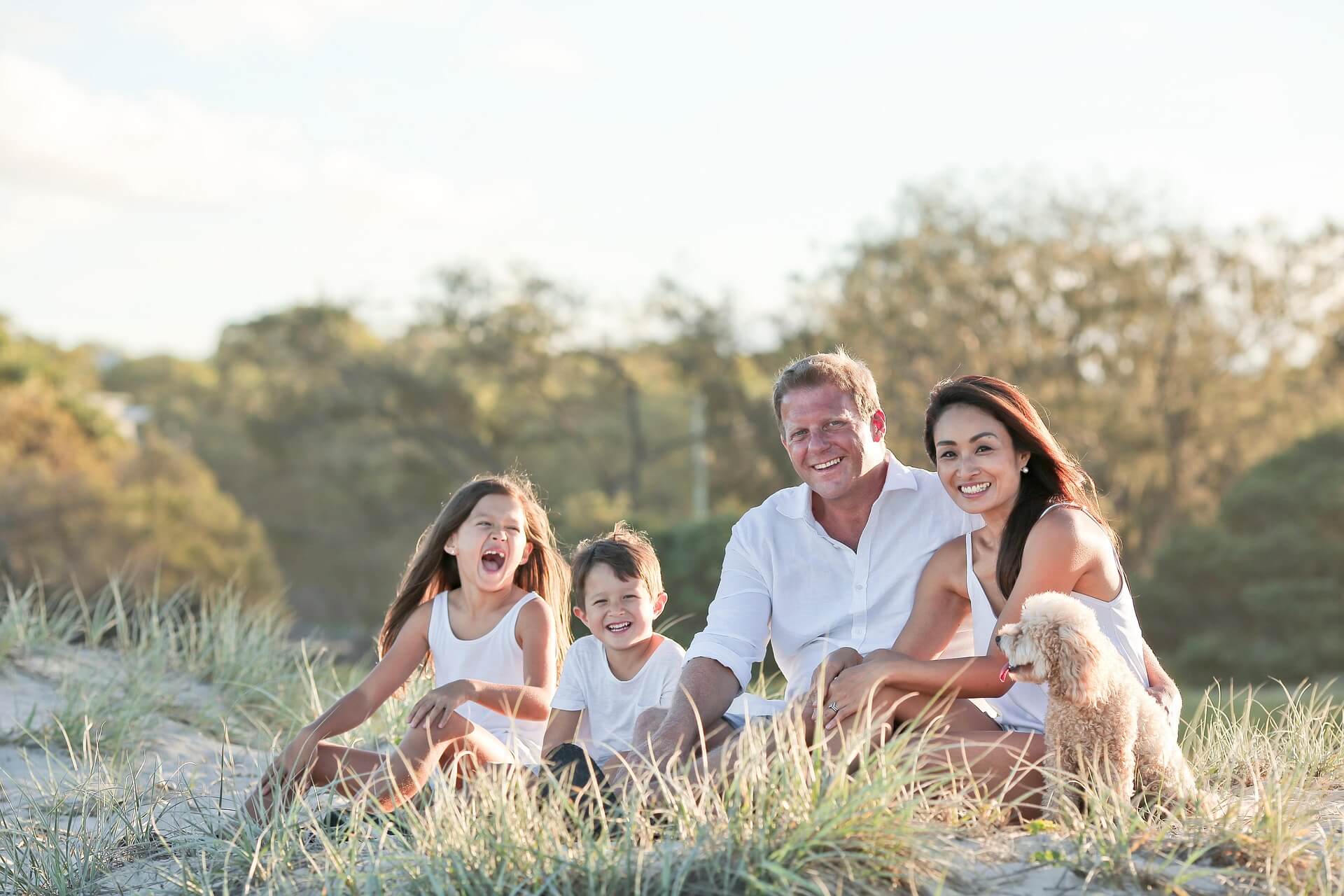 Family sitting together in the dunes at golden hour
